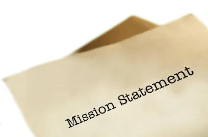 A group of hands holding a peice of paper that reads "Mission Statement"